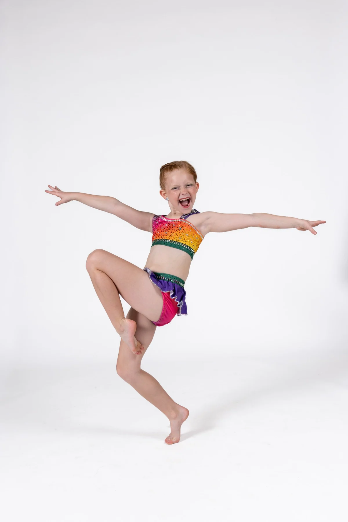 Young dancer expressing joy and confidence in a colorful costume